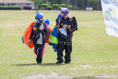 Skydivers walking in together from the landing area